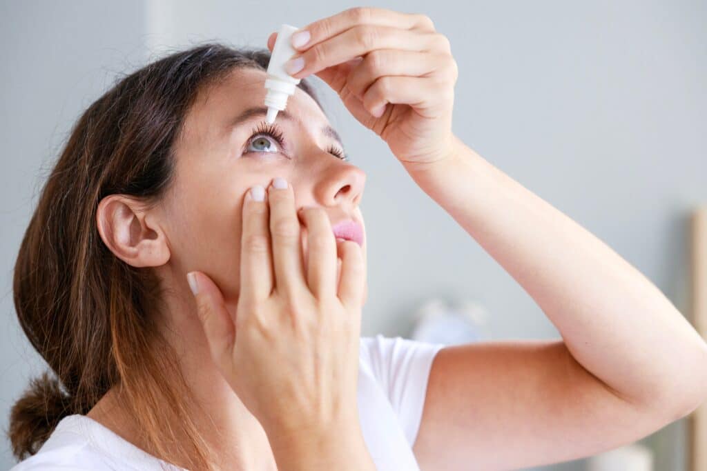 woman using eye drops to treat dry eye