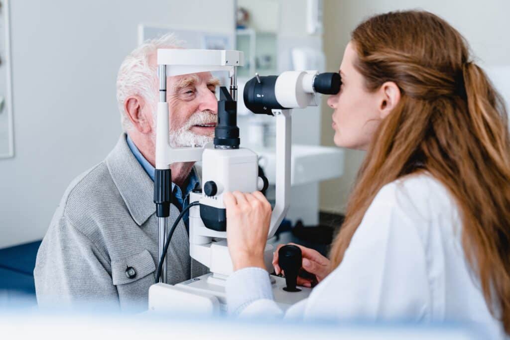 Female ophthalmologist giving eye exam to older man