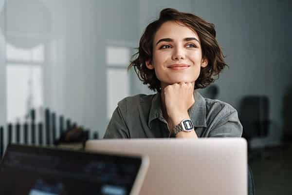 Woman Smiling on a Laptop Computer